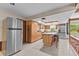 Kitchen featuring wood cabinetry, stainless steel appliances, tile flooring, and eat in kitchen island at 651 Percheron Cir, Nokomis, FL 34275
