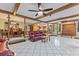 Spacious living room with tile flooring, ceiling fan, and views of the dining area and modern kitchen at 651 Percheron Cir, Nokomis, FL 34275