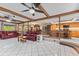 Open concept living room with wood beam accents, tile flooring, and access to kitchen and dining area at 651 Percheron Cir, Nokomis, FL 34275