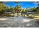 Outdoor picnic area with multiple shaded pavilions, tables, and grills surrounded by trees and sandy ground at 651 Percheron Cir, Nokomis, FL 34275