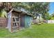 Green and wood shed in grassy back yard featuring lawn irrigation and mature trees for shade at 651 Percheron Cir, Nokomis, FL 34275
