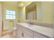 Bathroom with a window, toilet, sink, and vanity with a mirror and lighting at 705 Cadiz Rd, Venice, FL 34285