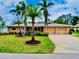 Charming single-story home boasts a two-car garage, lush lawn, and mature palm trees adding to its curb appeal at 705 Cadiz Rd, Venice, FL 34285