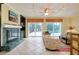 Cozy living room with a fireplace, ceiling fan, and sliding glass doors leading to the pool at 705 Cadiz Rd, Venice, FL 34285