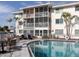 Exterior view of the community pool with lounge chairs, tables, and an adjacent three-story residential building at 708 Tamiami S Trl # 110, Venice, FL 34285