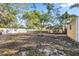 Spacious backyard with mature trees and a white fence at 742 Golf Dr, Venice, FL 34285