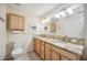 Well-lit bathroom with double sinks, granite countertops, and ample cabinet space at 742 Golf Dr, Venice, FL 34285