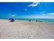 Expansive beach scene with turquoise waters and scattered umbrellas under a bright blue sky at 742 Golf Dr, Venice, FL 34285