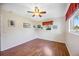 Cozy bedroom with wood laminate flooring, ceiling fan, and ample natural light at 742 Golf Dr, Venice, FL 34285