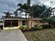 Charming home featuring lush landscaping, palm trees and a cozy front porch at 742 Golf Dr, Venice, FL 34285