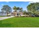Well-maintained home with a green lawn, palm trees, and beautiful landscaping at 742 Golf Dr, Venice, FL 34285