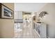 Bright hallway with white tile floors leading to a charming dining area and kitchen beyond at 742 Golf Dr, Venice, FL 34285