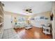 Cozy living room with wood-look flooring, white furniture, bright natural light, and a ceiling fan at 742 Golf Dr, Venice, FL 34285