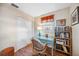 Cozy office space with blue glass desk, wicker chair, and natural light from the window at 742 Golf Dr, Venice, FL 34285