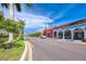 Scenic street view featuring shops with archways, palm trees, and lush landscaping at 742 Golf Dr, Venice, FL 34285