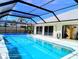 The pool is screened in and features a pool cover, surrounded by a spacious deck at 771 Stewart St, Englewood, FL 34223