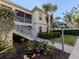 Lovely condo exterior with well-maintained landscaping, walkway, and stairs leading to the screened-in porch at 800 Gardens Edge Dr # 814, Venice, FL 34285