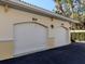Two-car garages with addresses, set against a backdrop of lush landscaping at 800 Gardens Edge Dr # 814, Venice, FL 34285