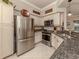 Modern kitchen with granite counters, stainless steel appliances, and tile backsplash at 800 Gardens Edge Dr # 814, Venice, FL 34285