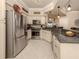 Modern kitchen with granite counters, stainless steel appliances, and tile flooring at 800 Gardens Edge Dr # 814, Venice, FL 34285
