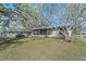 Charming home with a screened-in porch, surrounded by lush landscaping and trees at 8155 Mossborger Ave, North Port, FL 34287