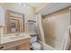 Neutral bathroom featuring a shower-tub combo and a wood vanity with a large mirror at 8155 Mossborger Ave, North Port, FL 34287