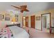 Comfortable bedroom with a ceiling fan, view to bathroom, and classic furnishings at 8155 Mossborger Ave, North Port, FL 34287