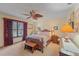 Comfortable bedroom with a ceiling fan, large window, and classic furnishings at 8155 Mossborger Ave, North Port, FL 34287