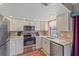 Well-lit kitchen featuring stainless appliances, white cabinets, granite countertops, and a stylish accent rug at 8155 Mossborger Ave, North Port, FL 34287