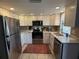 Well-lit kitchen featuring stainless appliances, white cabinets, granite countertops, and a stylish accent rug at 8155 Mossborger Ave, North Port, FL 34287