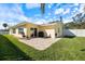 A cozy outdoor patio features chairs and a grill, perfect for relaxing in the serene backyard of this charming home at 929 The Rialto, Venice, FL 34285
