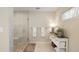 Modern bathroom with a glass-enclosed shower, decorative cabinet, and plush white towels at 929 The Rialto, Venice, FL 34285