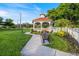 Charming gazebo on a well-manicured lawn with benches, perfect for relaxing outdoors at 929 The Rialto, Venice, FL 34285