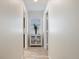 Well-lit hallway featuring a stylish accent cabinet and neutral wall paint at 929 The Rialto, Venice, FL 34285