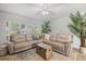 Bright living room with comfortable seating, wooden chest coffee table, and large windows with plantation shutters at 929 The Rialto, Venice, FL 34285