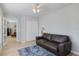 Bright room featuring a brown leather sofa, wood-look floors, and a ceiling fan at 929 The Rialto, Venice, FL 34285