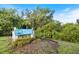 Charming 'Welcome to Venice' sign nestled amidst lush greenery and colorful flowerbeds at 929 The Rialto, Venice, FL 34285