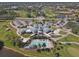 Stunning aerial view of a clubhouse, golf course, pool, and parking lot in a vibrant community at 945 Chickadee Dr, Venice, FL 34285