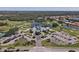 An aerial view reveals a community clubhouse, golf course, parking lot and nearby homes at 945 Chickadee Dr, Venice, FL 34285