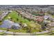 Aerial view of golf course community with mature trees, a lake, and well-kept lawns at 945 Chickadee Dr, Venice, FL 34285