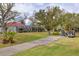 Well-manicured backyard with green grass, a sidewalk, and golf carts at 945 Chickadee Dr, Venice, FL 34285