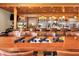 A closer view of the beautiful wooden bar area with well-stocked shelves and comfortable seating at 945 Chickadee Dr, Venice, FL 34285