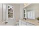 Bright bathroom features a large window, white cabinets and sink at 945 Chickadee Dr, Venice, FL 34285