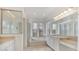 Bright bathroom featuring double sinks, a soaking tub, and a glass shower at 945 Chickadee Dr, Venice, FL 34285