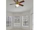 Bright room with a ceiling fan and multiple windows providing ample natural light at 945 Chickadee Dr, Venice, FL 34285