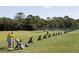 Golfers practice their swing at the community driving range on a sunny day at 945 Chickadee Dr, Venice, FL 34285