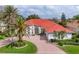 Stunning single-Gathering home with a beautiful red roof, well-manicured lawn, and circular brick driveway at 945 Chickadee Dr, Venice, FL 34285