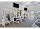 Well-equipped gym with state-of-the-art machines, two televisions, and bright natural light at 945 Chickadee Dr, Venice, FL 34285