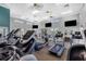 Spacious gym featuring treadmills, elliptical machines, and multiple TVs for entertainment at 945 Chickadee Dr, Venice, FL 34285