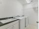 Functional laundry room with a sink, cabinets, and modern washer and dryer units at 945 Chickadee Dr, Venice, FL 34285
